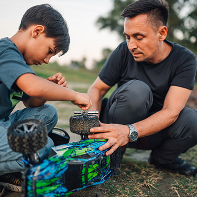 a father helping a son fix a broken toy car