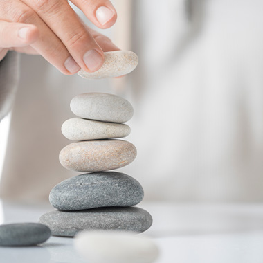 a person stacking pebbles symbolising personal growth