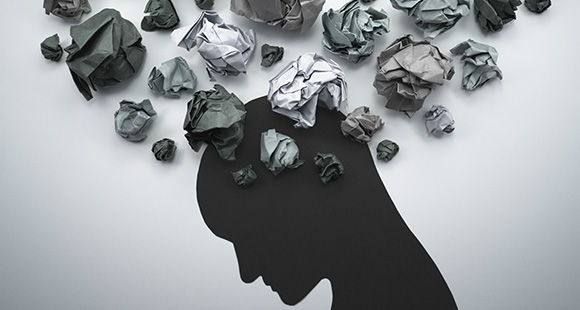 a silhouette of a person with scrunched up paper floating over their head 